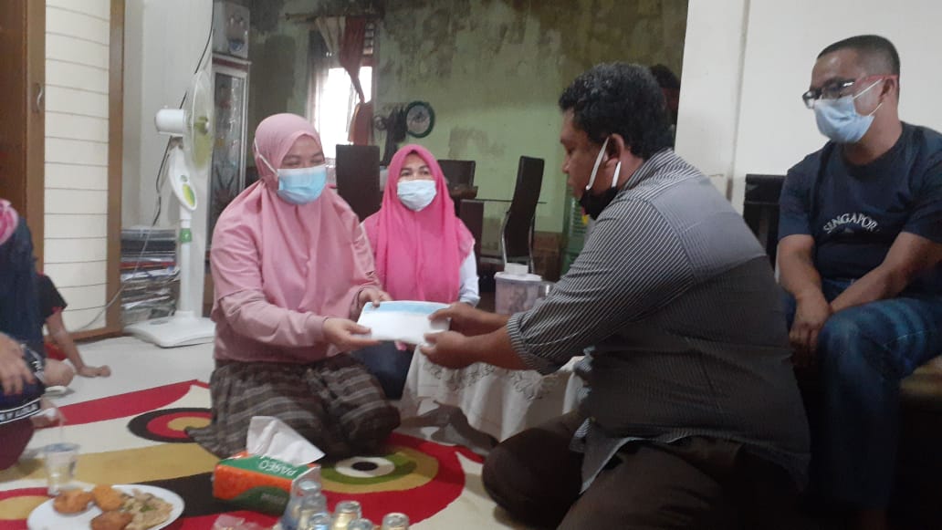 Sekretaris PWI Riau Peduli Satria Utama Batubara menyerahkan santunan kepada istri almarhum Moralis, Maya.(PWI RIAU FOR RIAUPOS.CO)
