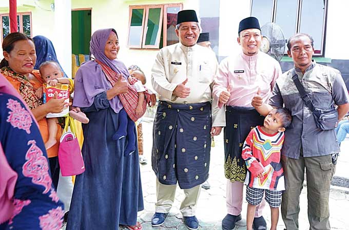 Bupati Siak Alfedri bersama Wabup Husni Merza foto bersama warga dalam Program Bujang Kampung di Kampung Tualang Timur, Kecamatan Tualang.Â 