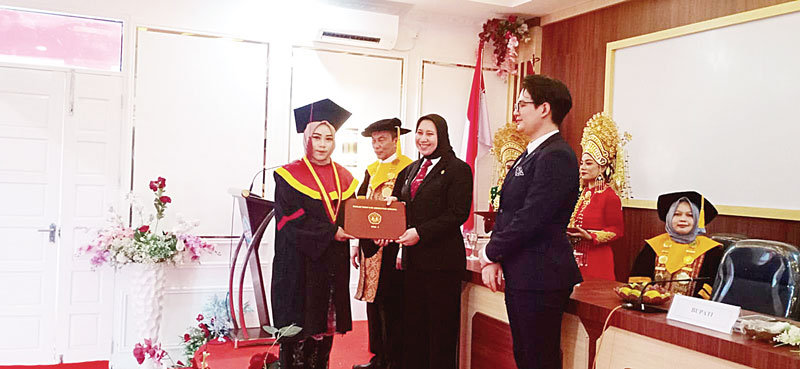 Bupati Inhu Rezita Meylani Yopi SE menyerahkan ijazah kepada salah seorang peserta wisuda, Kamis (5/10/2023).