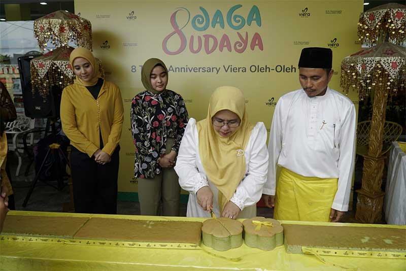 Owner Viera Oleh-Oleh,  Viera dan Rahmad memotong produk baru yang di-launching yaitu bolu panam sepanjang 8 meter saat acara ulang tahun ke-8 Viera Oleh-Oleh, Sabtu (20/5/2023).