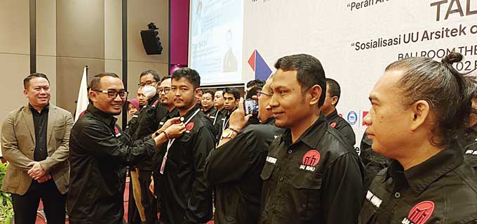 Ketua IAI Riau Sam Ani Huda menyematkan pin kepada salah seorang Pengurus IAI Riau, disaksikan Ketua Umum IAI Pusat Ar Georgius Budi Yulianto IAI AA (kiri) di Hotel The Zuri, Kamis (2/2/2023).