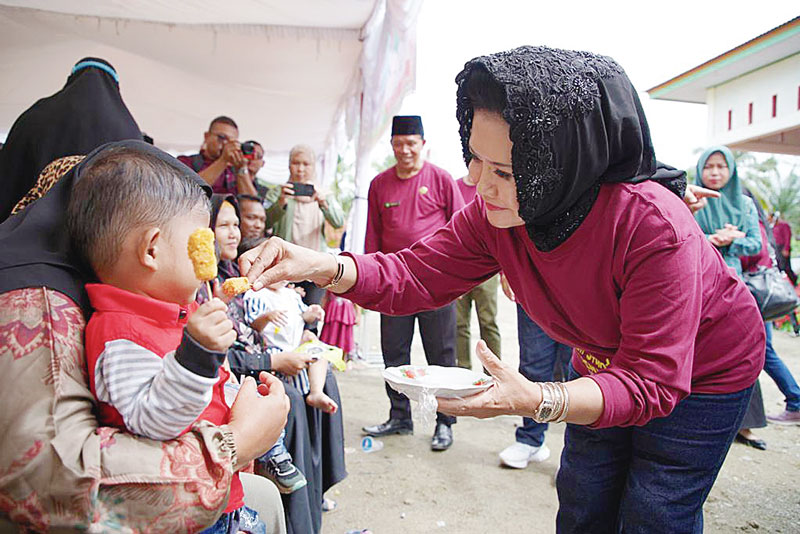 Bunda Paud Rohul Hj Peni Herawati Sukiman memÂ­berikan makanan tambahan bergizi kepada salah seorang balita yang dipusatkan di Desa Rambah Tengah Hulu Kecamatan Rambah, Kamis (20/7/2023).