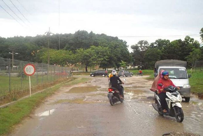 Kondisi jalan menuju RSUD Selasih Pelalawan yang mengalami kerusakan parah dan berlubang, namun belum dilakukan perbaikan. Sehingga para pengendara roda dua harus ekstra hati-hati melalui jalan tersebut, Kamis (13/8/2020). Amin Amran/Riau Pos