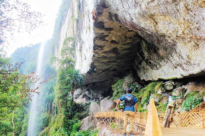 Objek  wisata Batu Tilam, Desa Kebun Tinggi, Kecamatan Kampar Kiri Hulu, menawarkan tempat beristirahat di balik gua dengan pemandangan air terjun, perbukitan dan hutan alami di kaki bukit barisan.