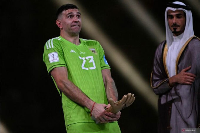 Kiper Argentina Emiliano Martinez berpose dengan sarung tangan emas sebagai penjaga gawang terbaik di Piala Dunia 2022 Qatar.