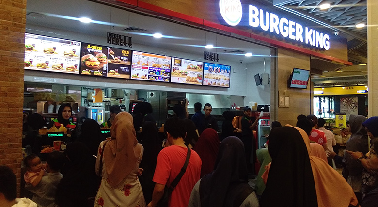 MENGANTRE: Puluhan konsumen setia Burger King Living World Pekanbaru rela mengantre untuk dapat menikmati menu-menu terbaru dari Burger King, Kamis (13/6/2019).prapti dwi lestari/riau pos