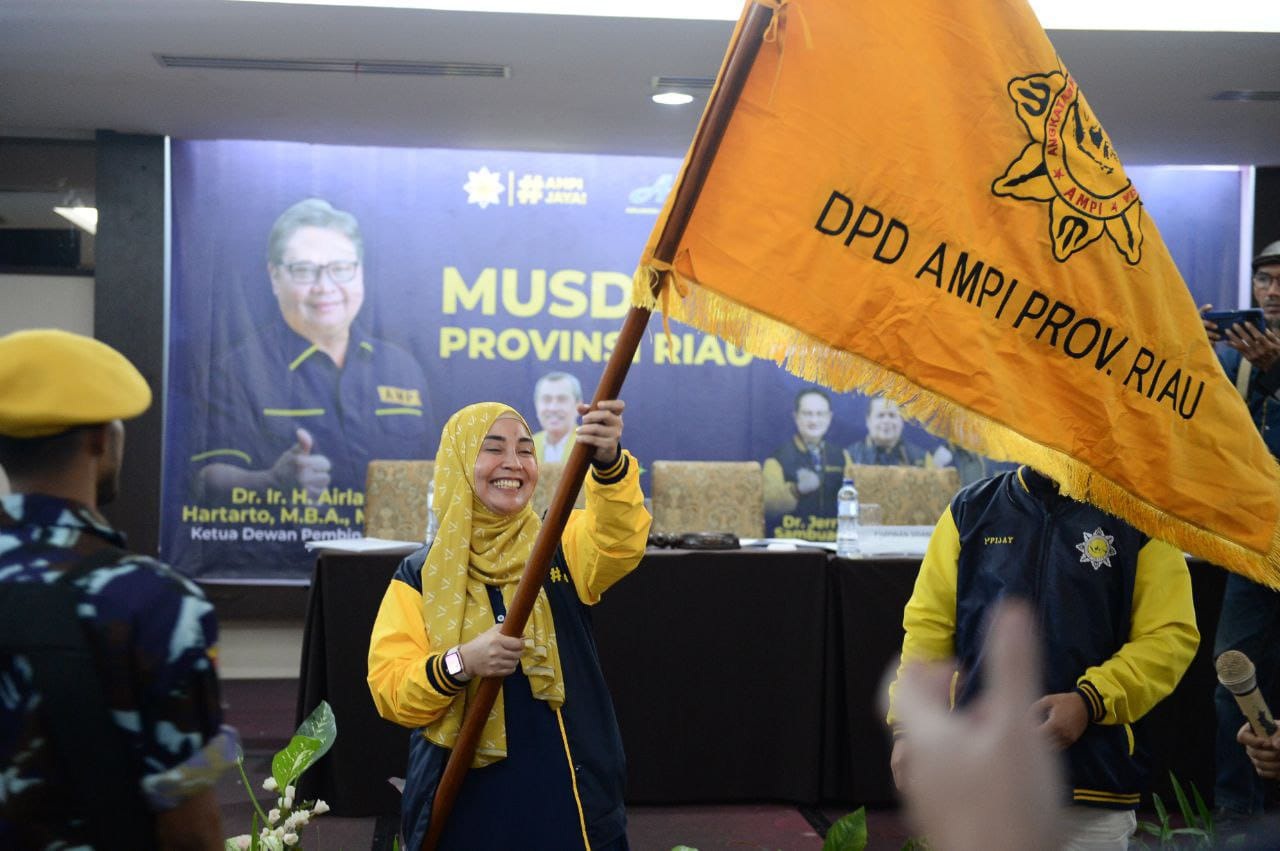 Ketua AMPI Provinsi Riau Sewitri mengibarkan bendera pataka usai Musda di Hotel Grand Central, Jumat (10/2/2023).