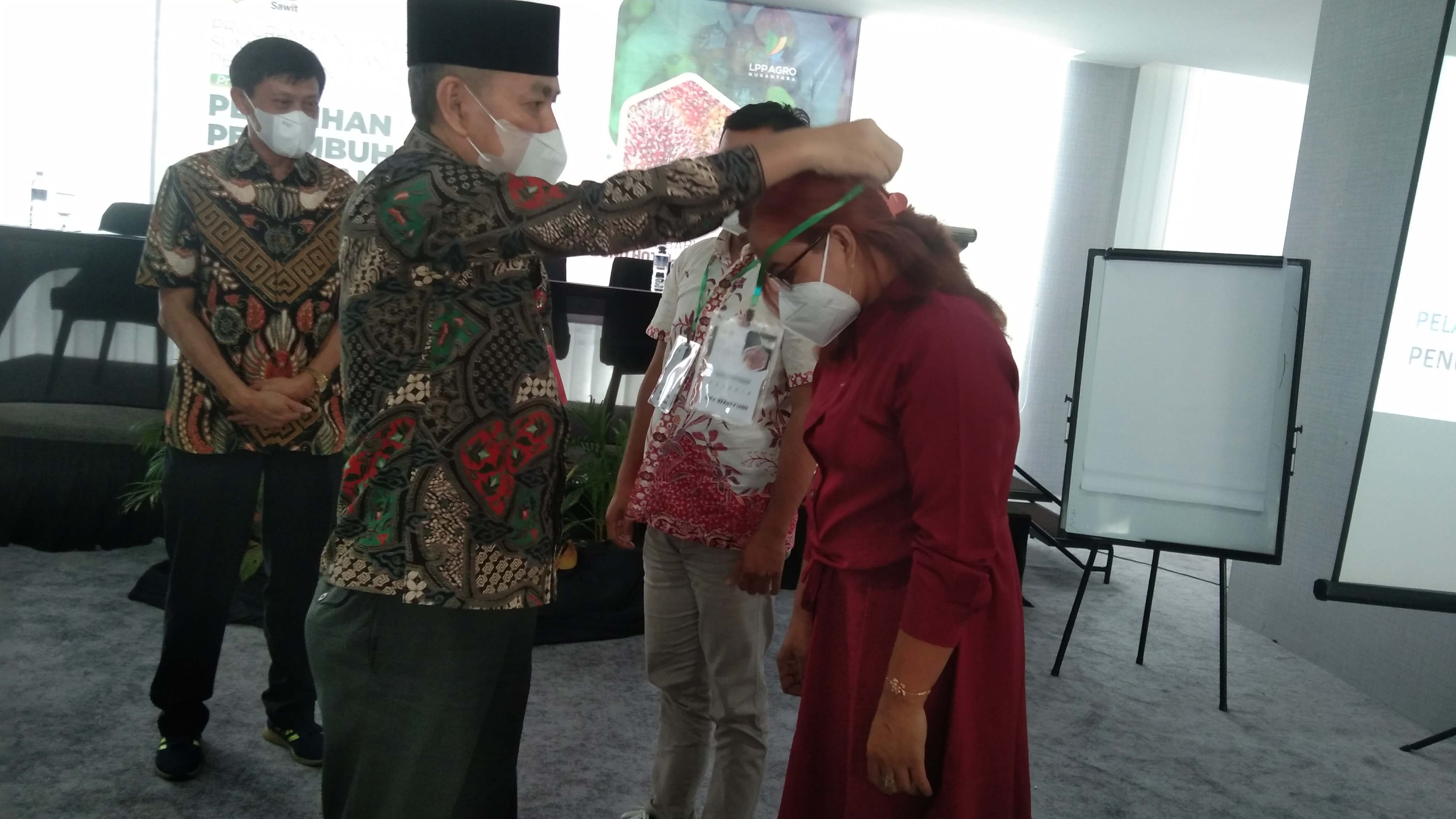 Kadisbun Riau Zulfadli didampingi Dirjen Perlindungan Perkebunan Kementan RI Ir Baginda Siagian, mengalungkan tanda peserta pelatihan di Hotel Bono, Pekanbaru, Kamis (23/6/2022).