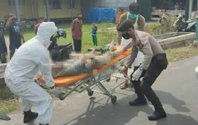Petugas polisi bersama satgas Covid-19 saat mengevakuasi jasad warga Desa Resam Lapis, Kecamatan Bantan yang ditemukan di tepi jalan persimpangan tiga, Senin (26/7/2021) sore.