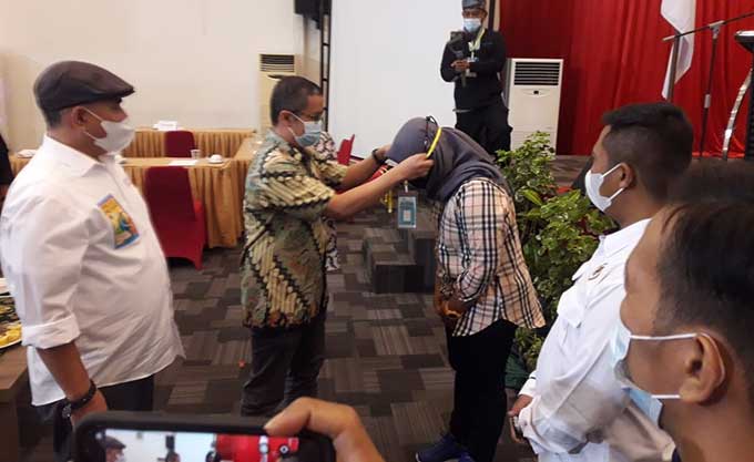 Manager Corporate Affair North PT CPI Rudi Arief mengalungkan tanda peserta UKW PWI Riau angkatan XVII di Grand Zuri Dumai, Jumat (25/6/2021).