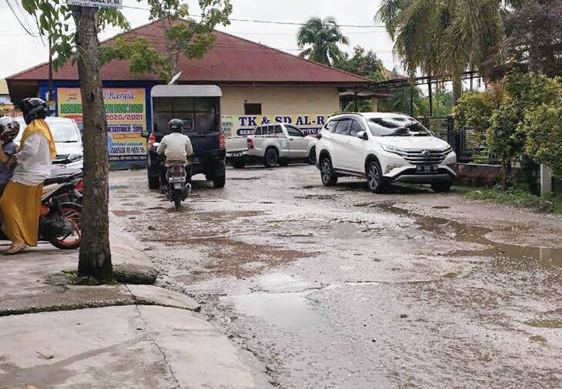 Rusak: Pengendara berhati-hati saat melintasi jalan rusak yang terdapat di Jalan Rawa Indah Kecamatan Marpoyan Damai, Kamis (2/1/2020). (PRAPTI DWI LESTARI/RIAU POS)