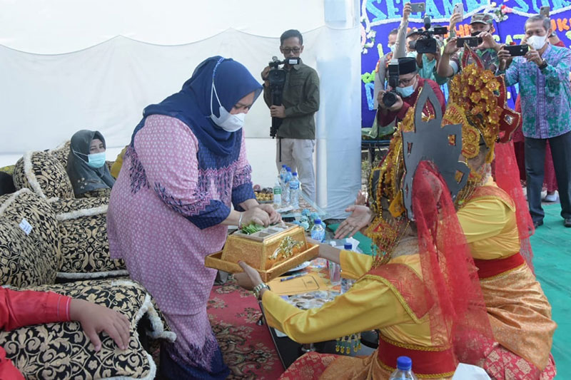 Bupati Bengkalis mengambil sirih saat melaunching Buku Legenda Gajah Sakti bersama sang penulisnya Maharani, di Jalan Jawa Gang Sumur Gajah Sakti, Mandau, Bengkalis, Jumat (11/3/2022).