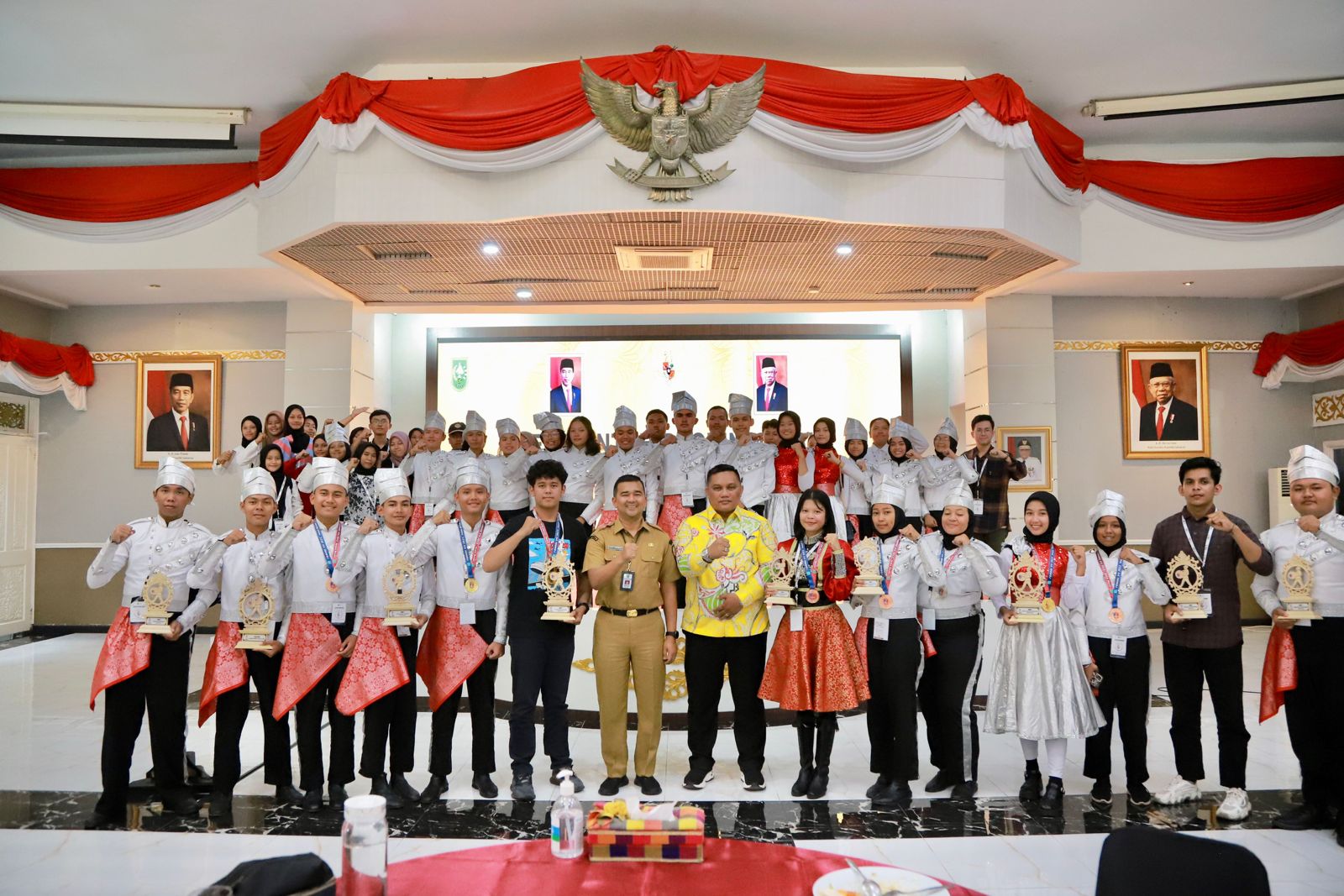 FOTO BERSAMA: Kadispora Riau H Boby Rachmat SSTP MSi AIFO-P mewakili Gubenur Riau H Syamsuar MSi foto bersama Marching band FYBI Riau usai penyambutan di Pekanbaru, Sabtu (8/7/2023) malam.
