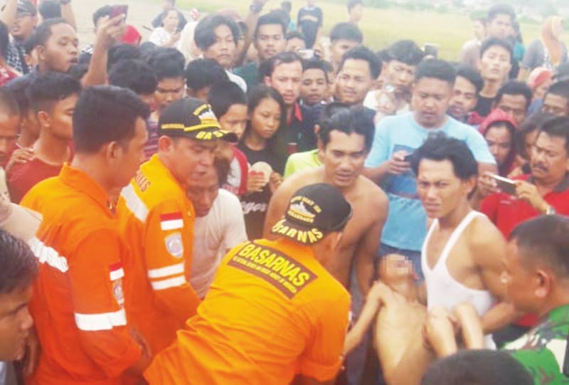 EVAKUASI KORBAN: Warga bersama Basarnas Pekanbaru Wilayah Kerja Dumai mengevakuasi korban yang tenggelam di waduk Pelindo Dumai, Jalan Terikat, Kamis (2/1/2020). (hasanal bulkiah/riau pos)