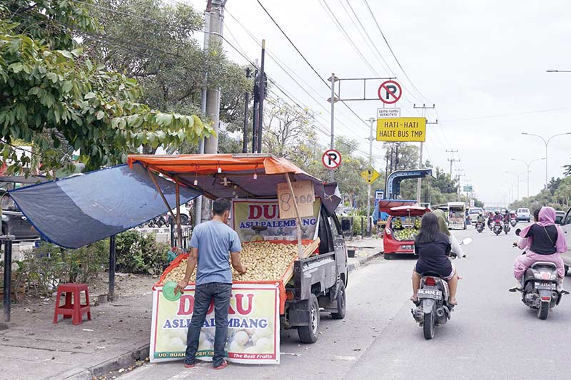 PEDAGANG Duku : Pedagang buah duku berjualan di sepanjang bahu Jalan HR Soebrantas Pekanbaru, Selasa (11/2/2020). Keberadaan pedagang buah duku tersebut sering menimbulkan kemacetan.  (DEFIZAL/Riau Pos)