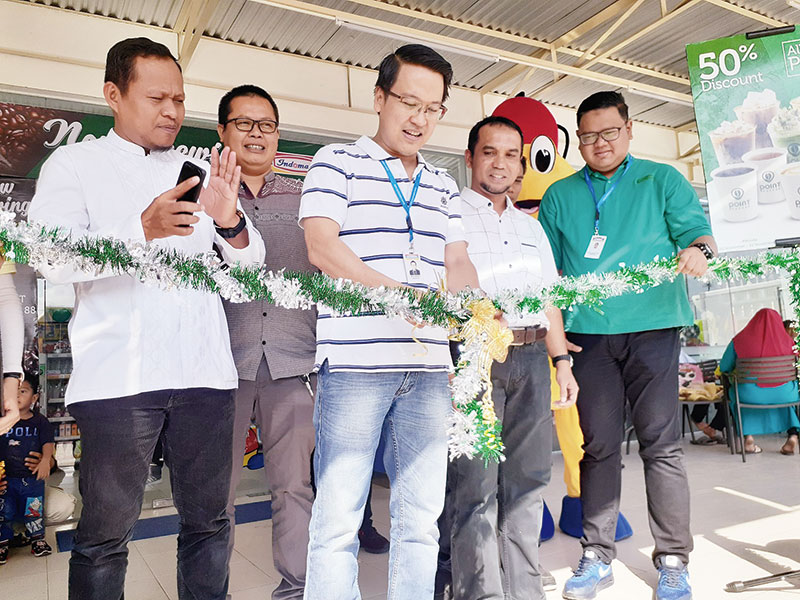 Branch Manager PT Indomarco Prismatama Jefri Hirokito menggunting pita didampingi Direktur Operasional Riau Pos HM Nazir Fahmi tanda dibukanya point coffee ke-13 di Indomaret Kubang Jaya 88.