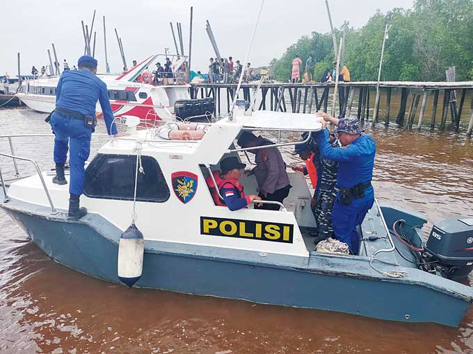 Warga dan personel kepolisian melakukan pencarian terhadap korban tenggelam di perairan Tanjung Buton, Kecamatan Sungai Apit, Siak, Selasa (27/12/2022).