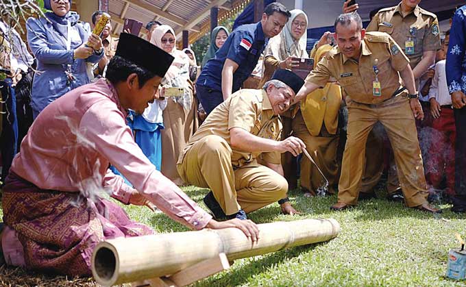Bupati Siak Alfedri memainkan permainan tradisional Melayu, meriam bambu dalam iven belajar bersama, pagelaran seni dan pameran temporer di Museum Budaya dan Sejarah Balairung Sri, Kabupaten Siak pada Senin (8/5/2023).