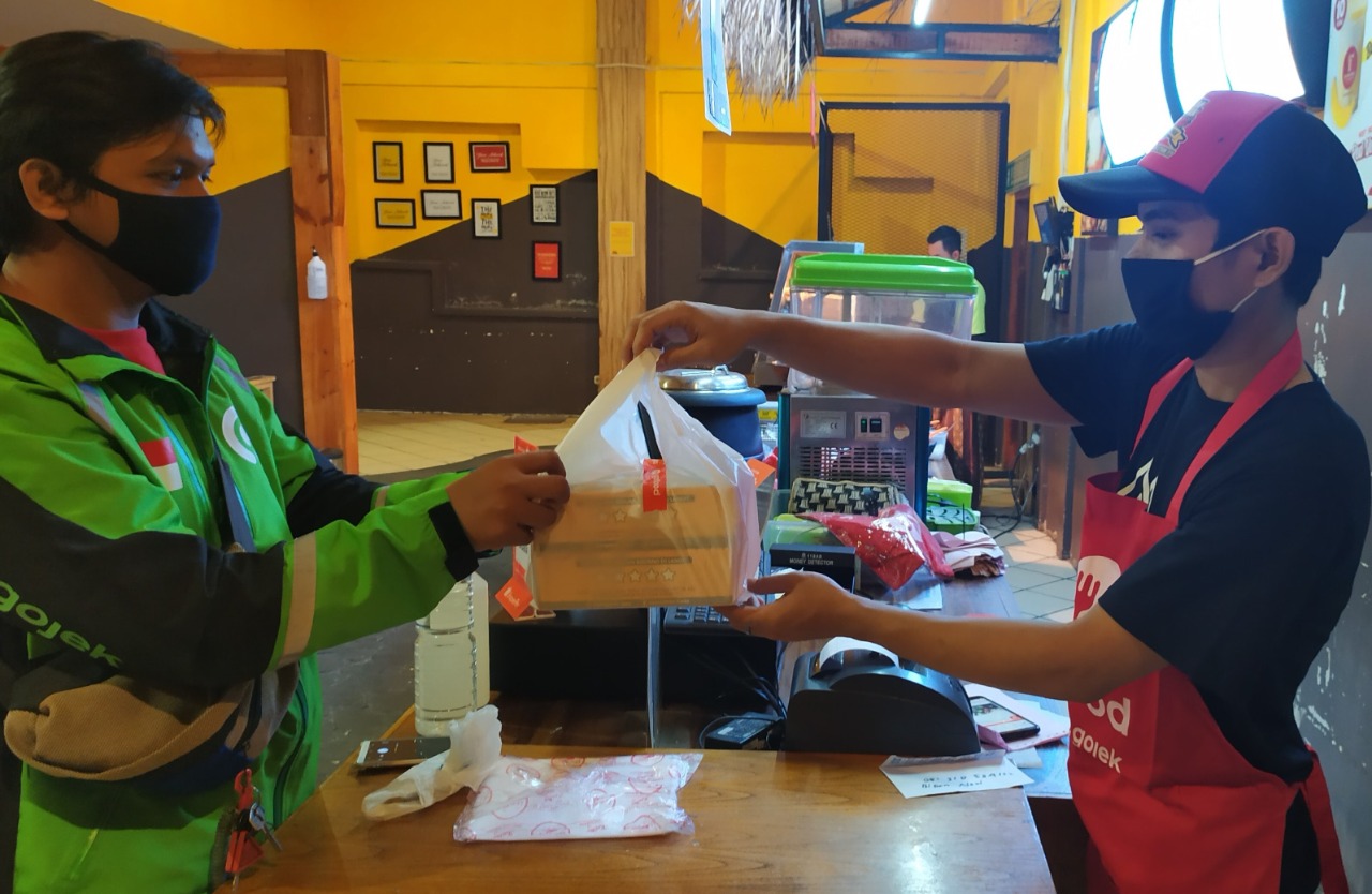 Mitra Gojek saat transaksi makanan dari layanan GoFood.(GOJEK FOR RIAUPOS.CO)
