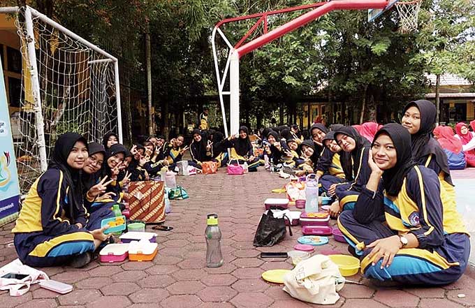 Para siswi foto bersama usai acara makan makanan bergizi di lapangan basket SMKN 2 Telukkuantan, Rabu (26/10/2022).