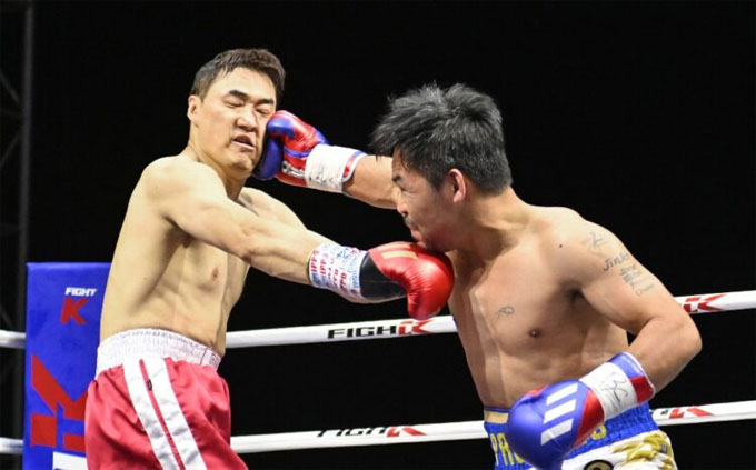 Legenda tinju Filipina Manny Pacquiao (kanan) menghajar YouTuber dari Korea Selatan DK Yoo dalam sebuah laga ekshibisi.