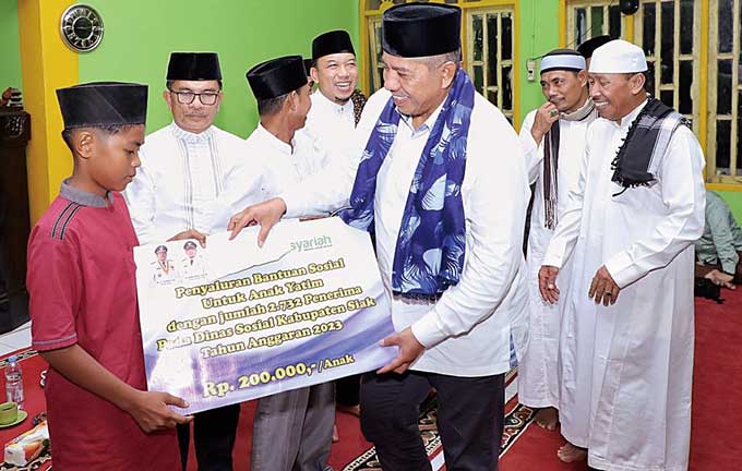 Bupati Siak AlfedriÂ dan Wabup Husni Merza menyerahkan bantuan kepada anak yatim dalam Safari Ramadan di Kampung Lubuk Umbut, Kecamatan Sungai Apit pada Jumat (7/4/2023