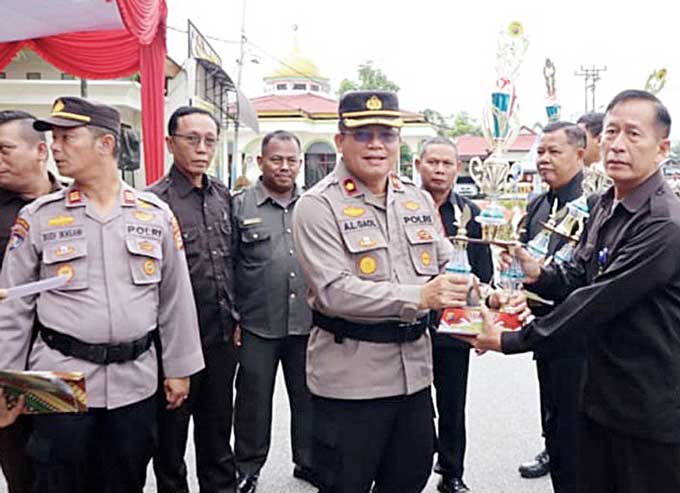 Wakapolres Pelalawan Kompol Antoni Lumban Gaol SH MH menyerahkan penghargaan kepada satpam berprestasi usai memimpin upacara Hari Ulang Tahun (HUT) ke-42 Satpam di halaman Mapolres Pelalawan, Senin (30/1/2023).