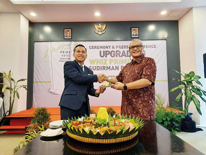 Corp Director of Operational Intiwhiz Hospitality Management Tito N Munawar (kanan) memberikan potongan tumpeng pertama kepada General Manager Whiz Prime Hotel Sudirman Pekanbaru Ismail Sazali (kiri) dalam agenda ceremony & press conference upgrading Whiz