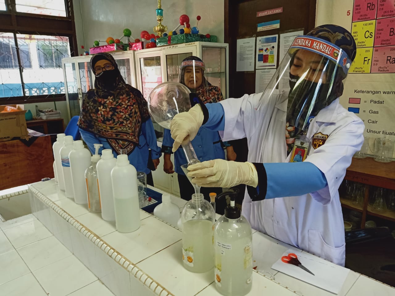 Kepala SMA Cendana Mandau, Dra Wiselmi MM bersama tim laboratorium Kimia saat menunjukan proses pembuatan Hand Sanitizer secara mandiri. (PANJI SYUHADA/RIAUPOS)