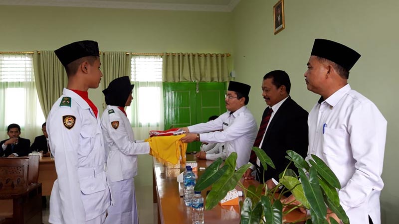 TERIMA BENDERA: Tim Paskibra MTs Muhammadiyah 02 menerima bendera Indonesia, English dan Arabic dari Kakanwil Kemenag Riau Dr H Mahyudin MA dalam launching penggunaan bahasa asing, Senin (16/3/2020).