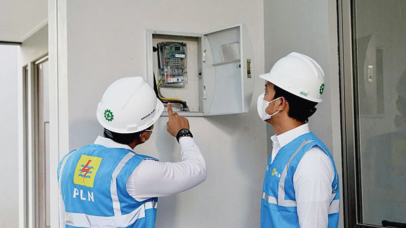 Petugas PLN melakukan penambahan daya pada instalasi listrik pelanggan.