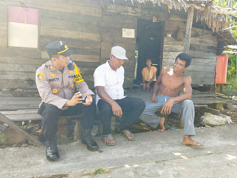 Kapolsek Bantan AKP Kasmandar Subekti berbincang-bincang dengan salah seorang warga suku akit di Desa Bantan Tengah Kecamatan Bantan l, Sabtu (23/12/2023) pagi.
