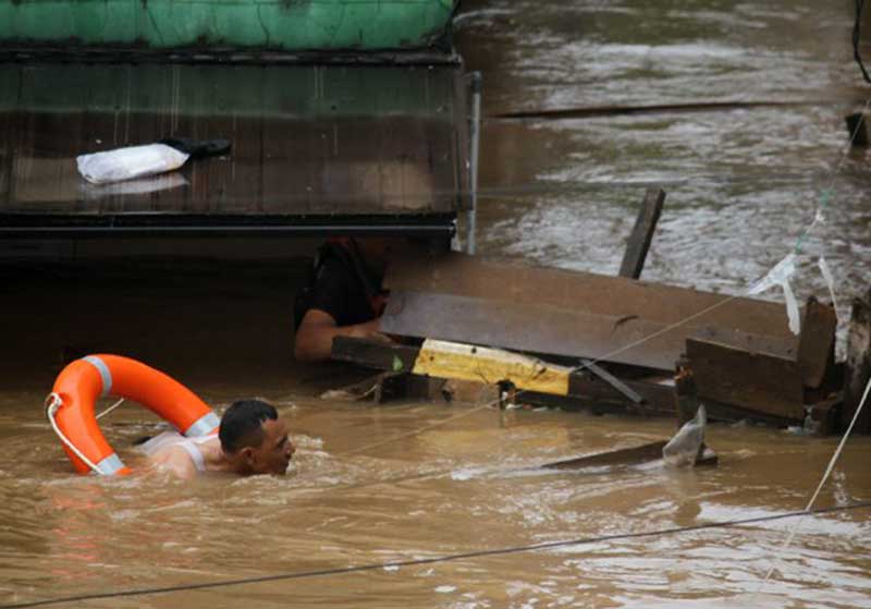 Warga berusaha melewati banjir di kawasan Cipinang Melayu, Jakarta, Rabu (1/1/2020). Banjir yang terjadi di kawasan tersebut akibat luapan air dari Kali Sunter. (Dery Ridwansah/ JawaPos.com)
