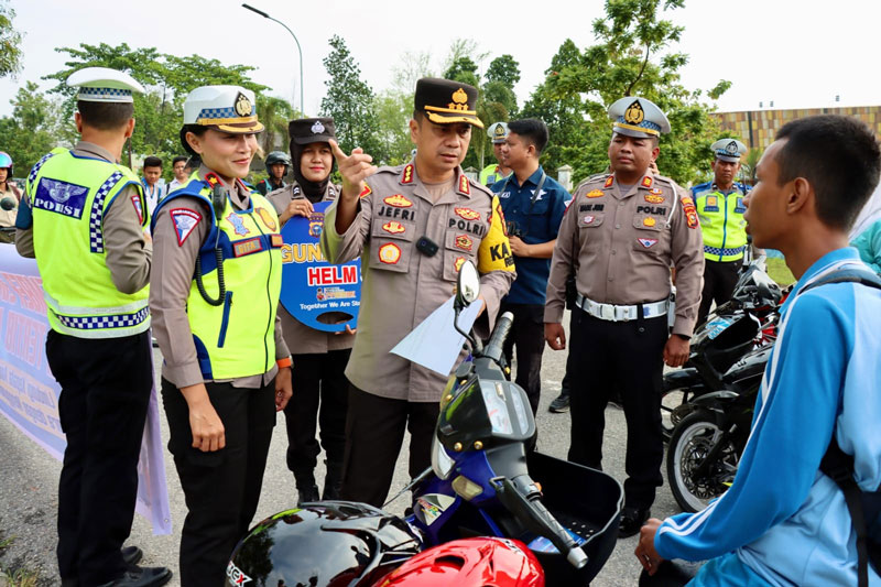 Kapolresta Pekanbaru Kombes Pol Jefri RP Siagian memberikan edukasi kepada salah seorang pelajar yang kedapatan mengendarai sepeda motor tanpa pakai helm di Jalan Yos Sudarso, Rumbai, Selasa (14/11/2023).