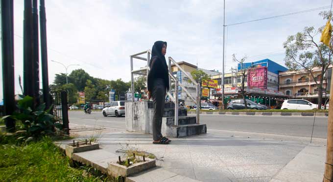 Calon penumpang berdiri menunggu kedatangan bus Trans Metro Pekanbaru (TMP) di Jalan HR Soebrantas Pekanbaru, Rabu (21/12/2022). Bangku tunggu di beberapa halte bus TMP banyak yang hilang.