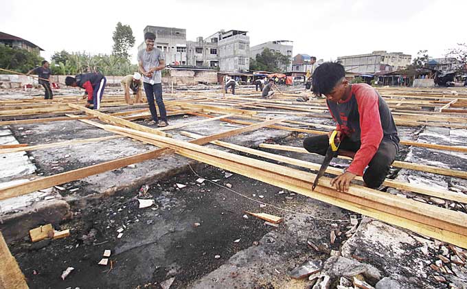 Sejumlah pekerja melakukan pengerjaan pembangunan Tempat Penampungan Sementara (TPS) pedagang di Pasar Cik Puan Pekanbaru, Senin (13/3/2023). Pembangunan ini ditargetkan selesai dalam dua pekan ke depan.
