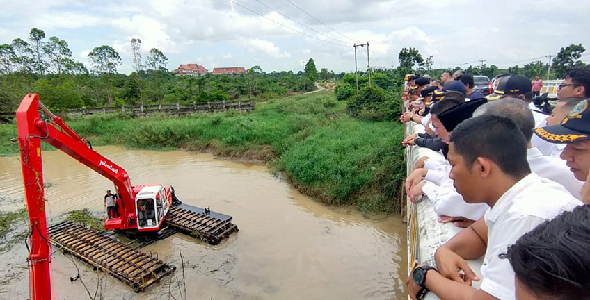 Beberapa pejabat dan masyarakat sedang menyaksikan demonstrasi penggunaan ekskavator amphibius buatan PT Pindad di Sungai Kerinci, Kecamatan Pangkalankerinci, Rabu (22/1/2020) siang. (M AMIN/RIAUPOS.CO)