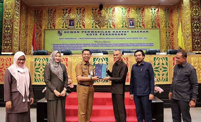 Pj SekkoÂ Pekanbaru Indra Pomi dan Wakil Ketua DPRD Kota Pekanbaru Ir Nofrizal MM menunjukkan berkas perda tentang Penyelenggaraan Administrasi KependudukanÂ yang sudah disahkan dalam rapat paripurna, Rabu (4/1/2023).Â 