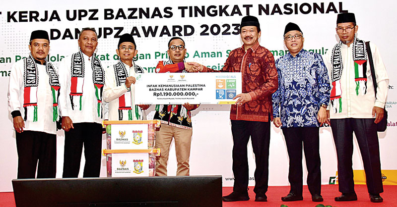 Pj Bupati Kampar Muhammad Firdaus SE MM didampingi Baznas Kabupaten Kampar PurwadiÂ Â  menyerahkan dana infak kemanusiaan untuk Palestina yang berasal dari masyarakat Kampar kepada Baznas RIÂ di Hotel Discovery Jakarta, Selasa (5/12/2023).