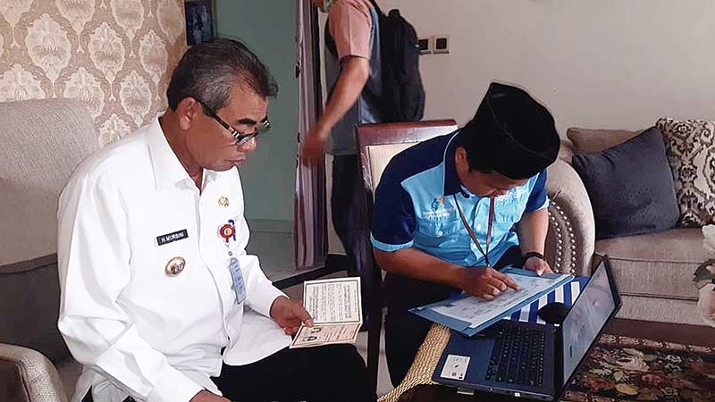 Bupati Kuansing Drs H Mursini MSi didampingi pegawai BPS saat mengisi data secara online di kediamannya Telukkuantan, Rabu (19/2/2020). (HUMAS PEMKAB FOR RIAU POS.CO)