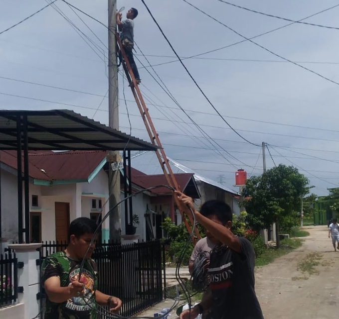 Secara swakelola, warga Perumahan Permata Fatikha, Desa Rimbo Panjang, Kampar memasang instalasi jaringan guna memasang lampu jalan di perumahan mereka, Ahad (27/9/2020).(MUSLIM NURDIN/RIAUPOS.CO)