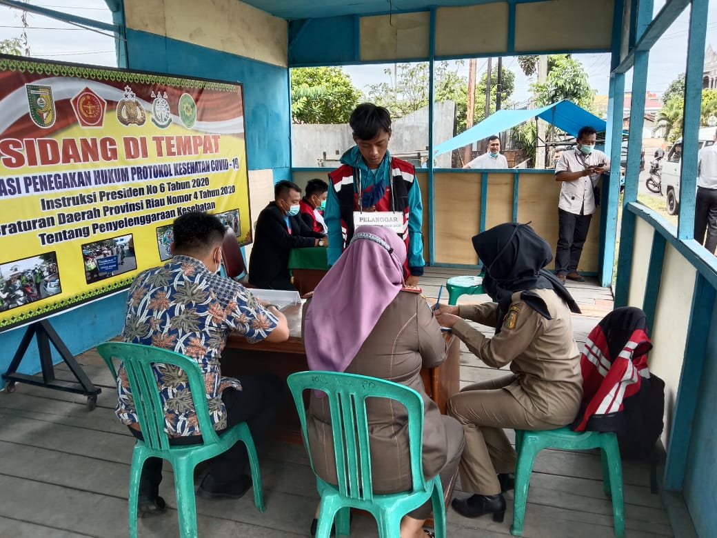 Pelanggar protokol kesehatan saat di data oleh petugas di Bundaran Tugu Carano Telukkuantan, Jumat (18/12/2020).(MARDIAS CAN/RIAUPOS.CO)