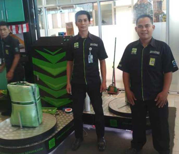 Pekerja Securitech Wrapping tengah mengemas barang bawaan penumpang di salah satu bandara.