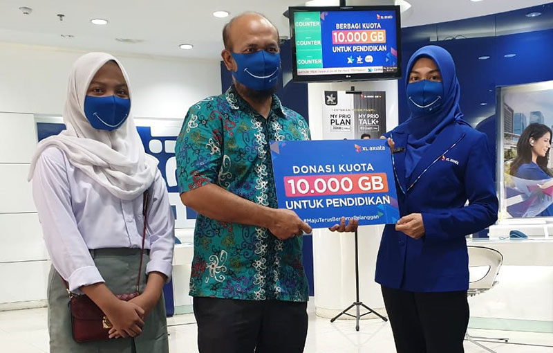 Jasmin, siswi SMK Negeri 6 Medan dan salah seorang gurunya, Drs Benhard Pakpahan, menerima donasi kuota data dari XL Axiata dalam rangka peringatan Hari Pelanggan Nasional 2020, di Medan, Kamis (3/9/2020). (XL FOR RIAUPOS.CO)