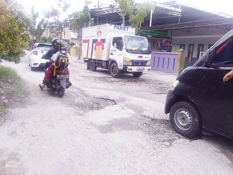 RUSAK: Pengendara harus berhati-hati saat melintasi Jalan Rawa Indah, Kecamatan Marpoyan Damai yang kondisinya rusak parah dan sempit, Kamis (19/12/2019). (Prapti dwi lestari/riau pos)