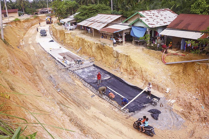 KERJA: Pekerja melakukan pengerjaan rigid Jalan Badak yang merupakan akses utama menuju Kompleks Perkantoran Pemko Pekanbaru di Kecamatan Tenayan Raya, Rabu (18/12/2019). Pengerjaan jalan ini ditargetkan selesai awal 2020. (EVAN GUNANZAR/RIAU POS)