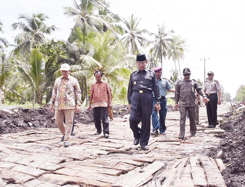 TINJAU PEMBANGUNAN: Bupati Inhil HM Wardan berjalan saat meninjau pembangunan infrastruktur di Kecamatan Pulau Burung, beberapa waktu lalu. (humas pemkab inhil)