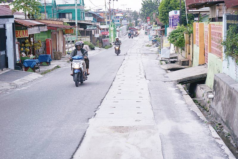 BEKAS GALIAN: Pengendara sepeda motor harus ekstra hati-hati melintas di jalan dekat bekas galian instalasi pembuangan air limbah (IPAL) di Jalan Melati, Kecamatan Sukajadi, Kota Pekanbaru yang tak kunjung diaspal, Ahad (8/12/2019). Kondisi ini sudah terj