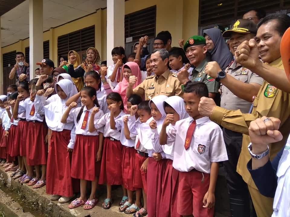 Gubernur Riau syamsuar, kapolda Irjen Pol Agung Setya, Danrem 031 Wirabima Brigjen TNI Muhammad Fajar dan Sekda Kuansing Dianto Mampanini menyemangati anak sekolah dan warga yang terdampak banjir di Desa Pulau Kumpai Pangean, Kuansing, Selasa (17/12/2019)