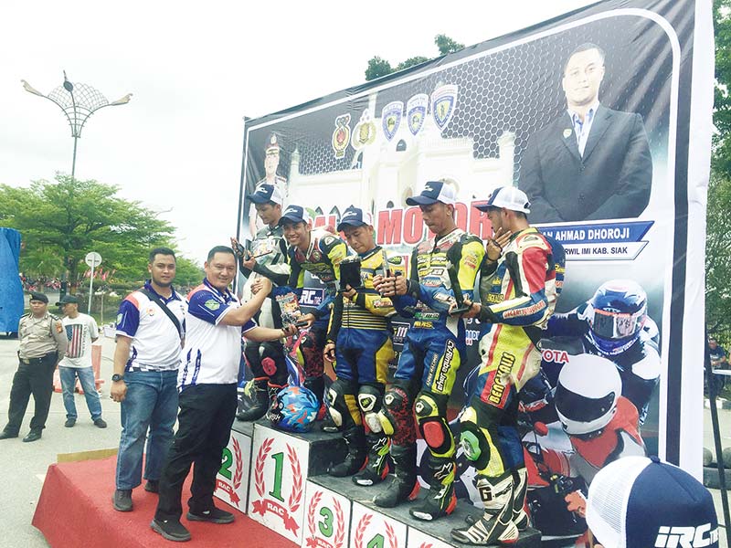 SERAHKAN TROFI: Kapolres Siak AKBP Doddy F Sanjaya menyerahkan trofi dan hadiah kepada para pemenang didampingi Ketua IMI Korwil Siak Wan Ahmad Dorroji di arena pertandingan, Ahad (15/12/2019). (MONANG LUBIS/RIAU POS)